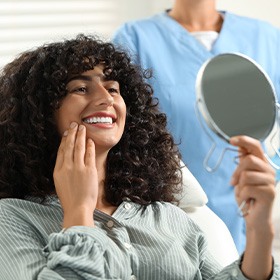 a woman admiring her smile in a mirror