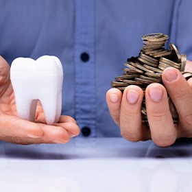 a man holding coins and a tooth model