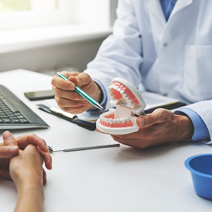 two people examining a denture model